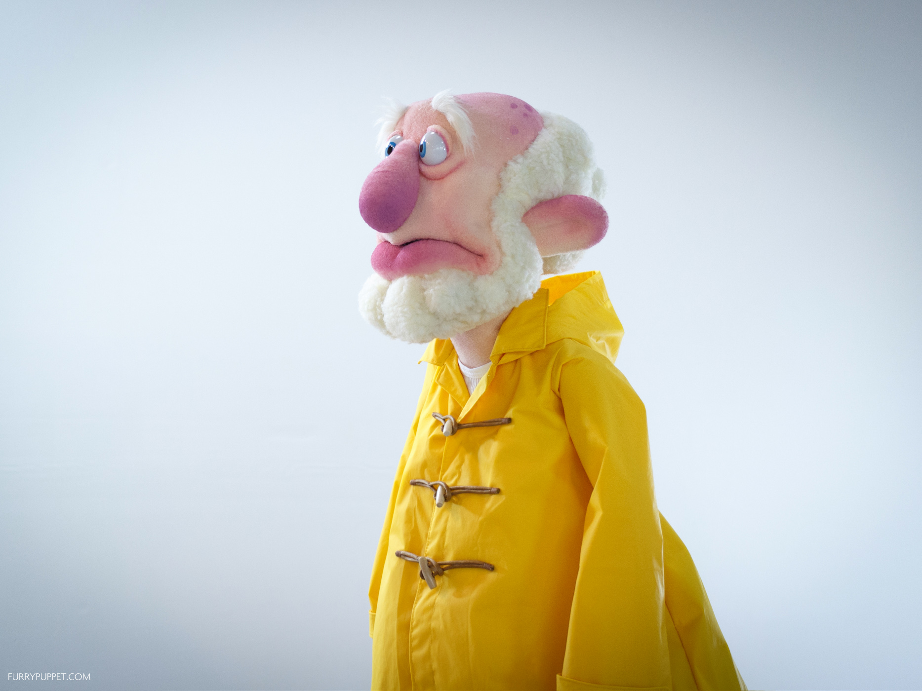 Old fisherman character puppet in a yellow raincoat by Furry Puppet Studio