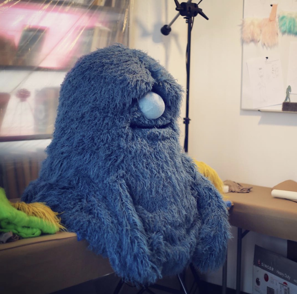 Large shaggy blue monster puppet on a stand in the Furry Puppet Studio workshop